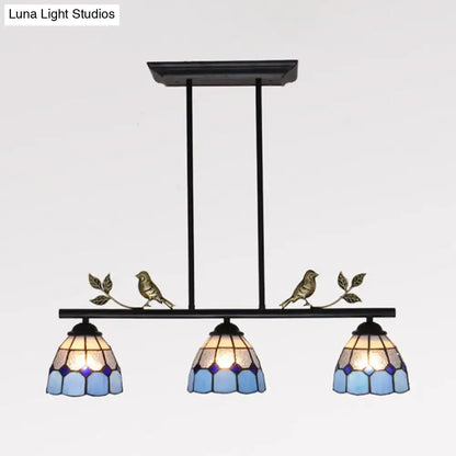 Black metal indoor island pendant with three blue and purple stained glass shades and brass bird figurines