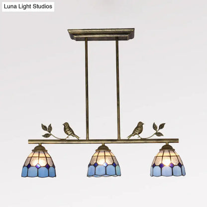 Antique brass indoor island pendant with three blue stained glass shades and decorative bird motifs for kitchen