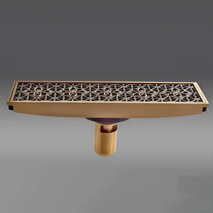 Antique brass carved floor drain cover with intricate geometric cutout pattern for bathroom use