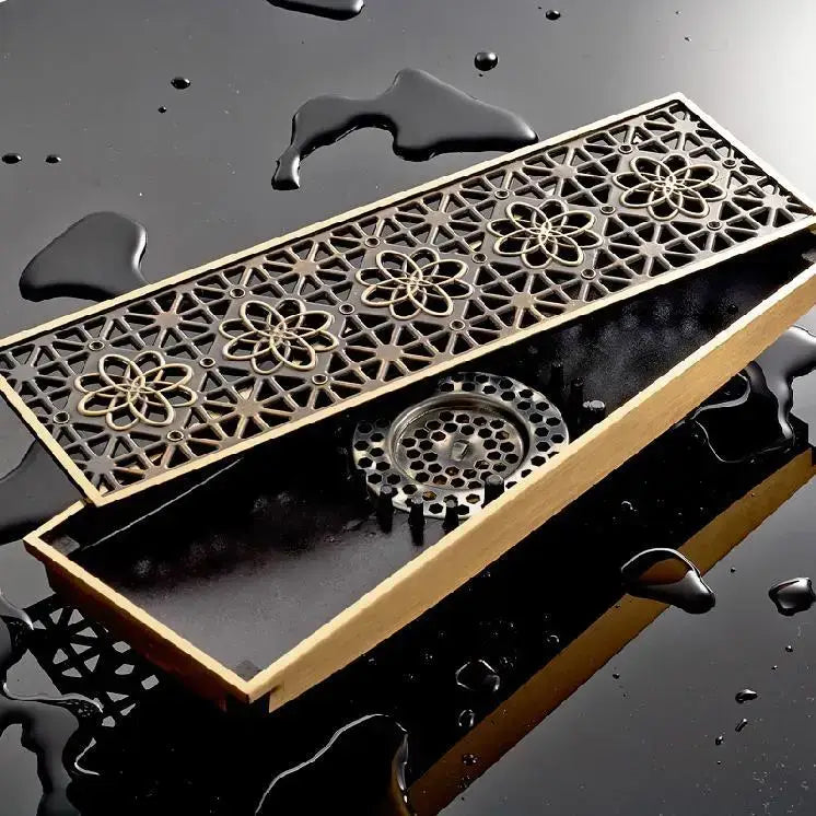 Antique brass carved floor drain cover with bronze floral and geometric cutouts and circular mesh filter inside