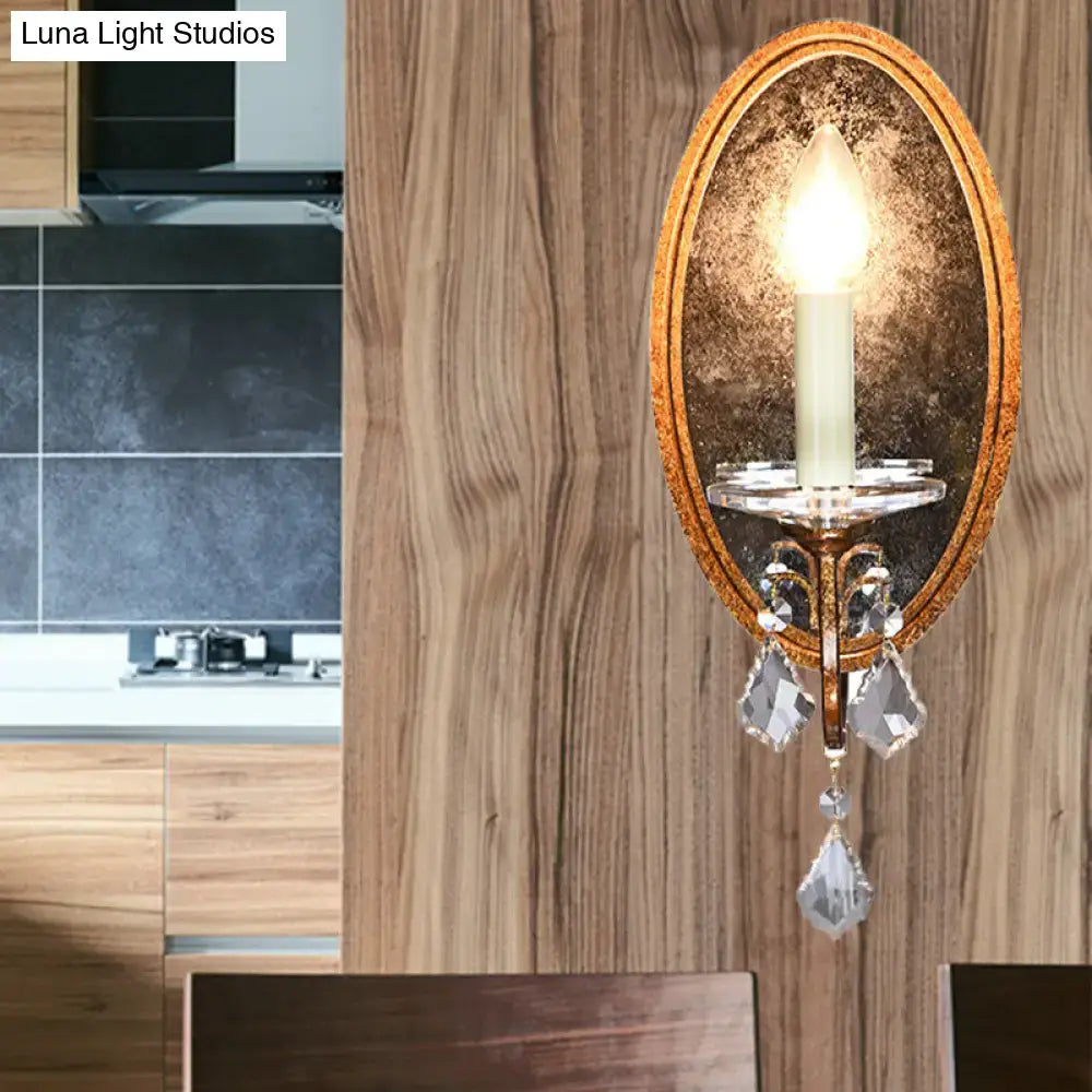 Antique brass wall sconce with clear crystal droplets and a candle-style bulb for bedroom candle light