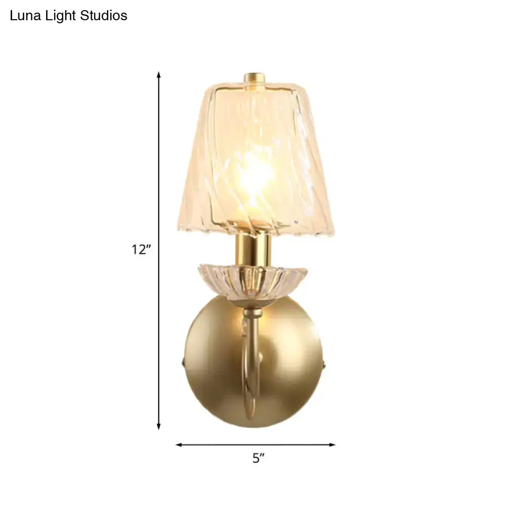 Antique brass conical sconce light with clear twisted glass shade and crystal-like amber petal detailing for bedroom