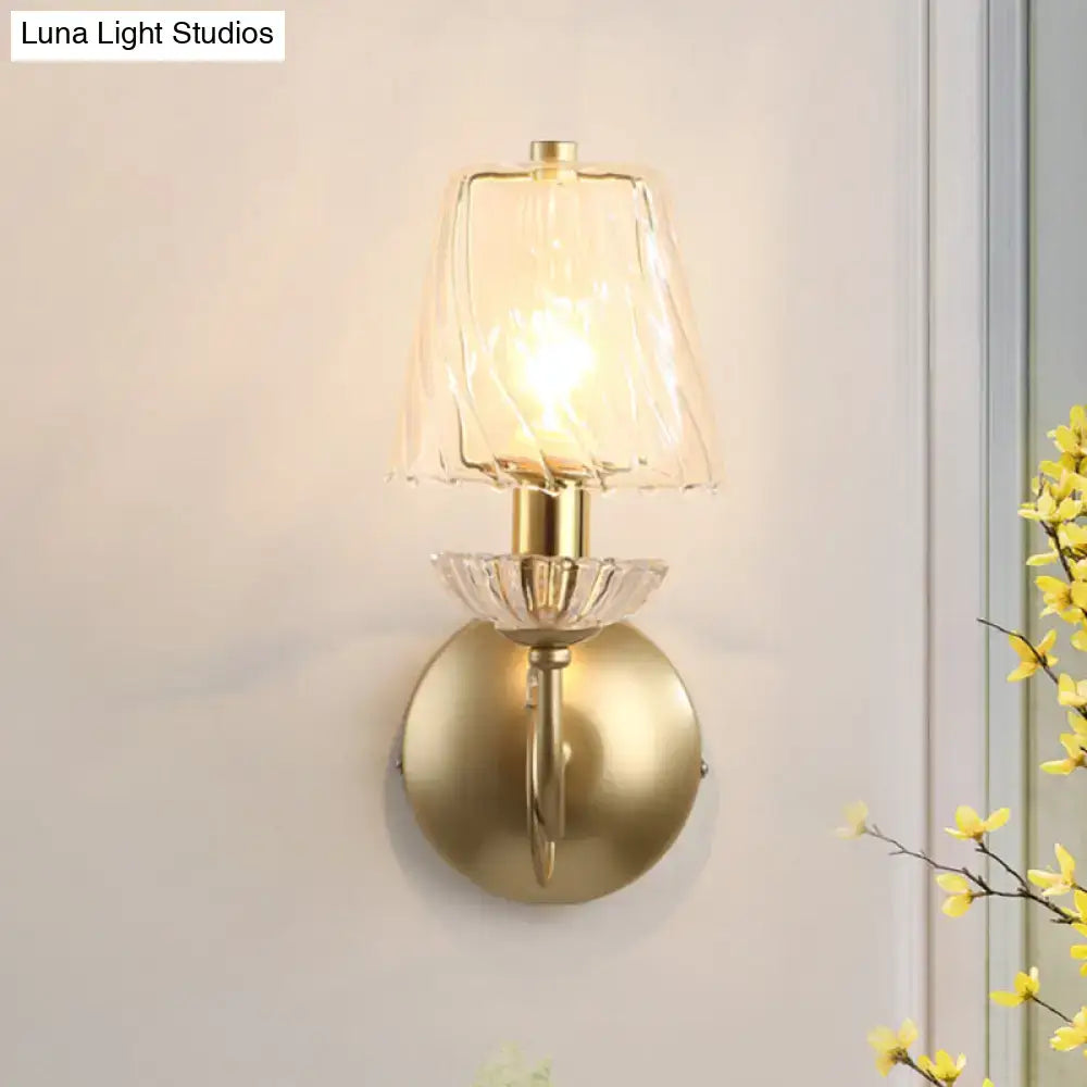 Antique brass conical sconce light with clear twisted glass shade and crystal accents for bedroom wall lighting