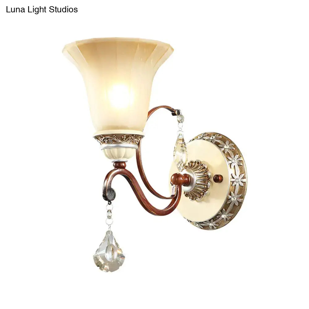Cream-colored glass shade bell wall sconce with bronze metal frame and crystal droplets in lodge style for bedroom use
