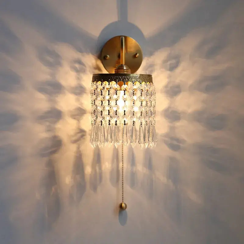 Antique brass crystal led wall sconce with gold-toned finish and cascading clear crystal droplets with pull chain light