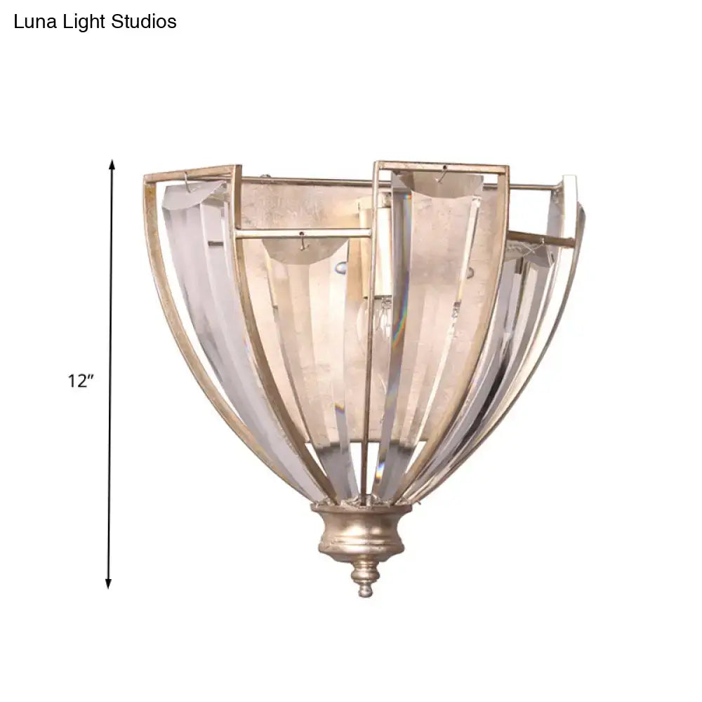 Antique brass curved wall sconce with brushed nickel finish and clear ribbed glass panels for bedroom use
