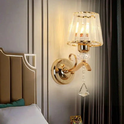 Gold-toned antique brass and dark bronze decorbites crystal led wall lamp with crystal lampshade and dangling crystals for living room