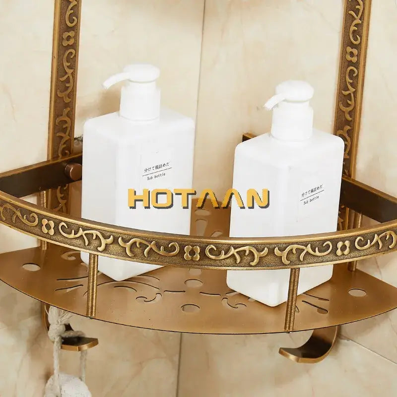 Two white soap dispensers on a decorbites antique aluminum brass double layer corner shelf for bathroom storage