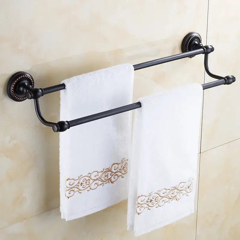 Black wrought iron double towel bar with ornate circular wall mounts and curved ends for bathroom use