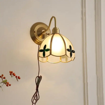 Antique brass glass brass wall sconce with cream petal-shaped stained glass shade and green black floral accents for dining room decorbites glass brass