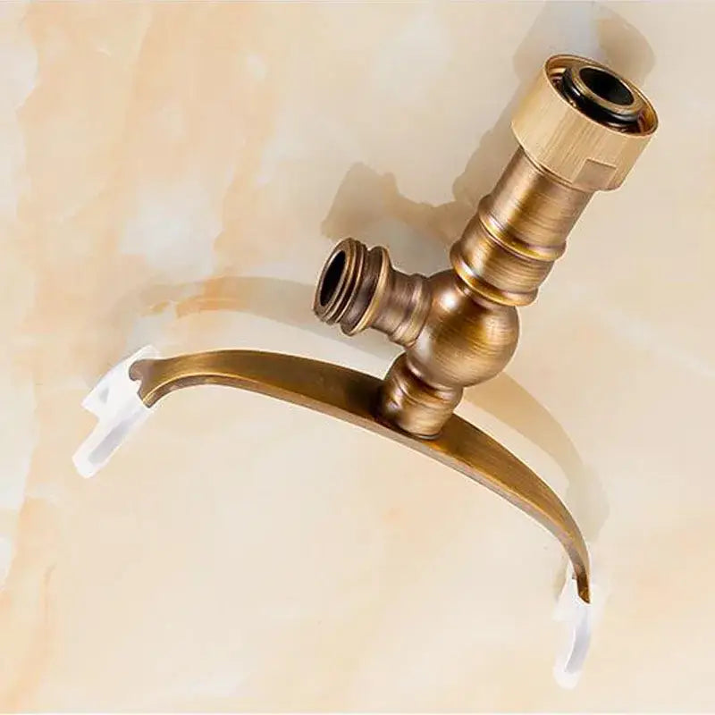 Antique brass hand shower holder hook with a curved spout and two threaded connections for shower holder use