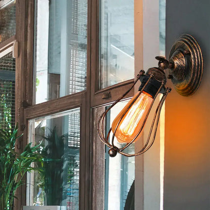Antique brass industrial wall lamp with wire cage and glowing Edison bulb for decorbites industrial wall sconce decor