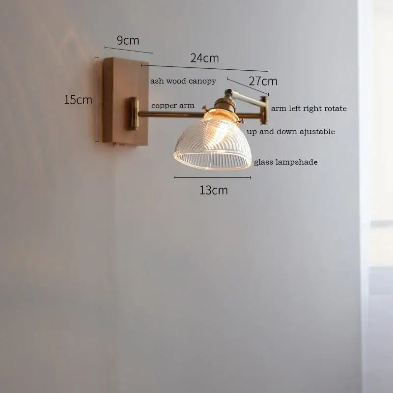 Adjustable wall light with warm-toned ash wood canopy copper arm and clear glass ribbed lampshade by decorbites clear glass