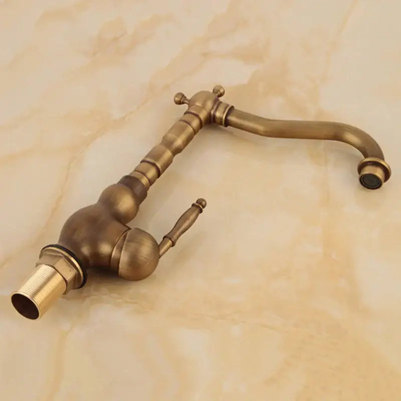Antique brass decorbites basin sink faucet with curved spout and ornate segmented handle design for bathroom use