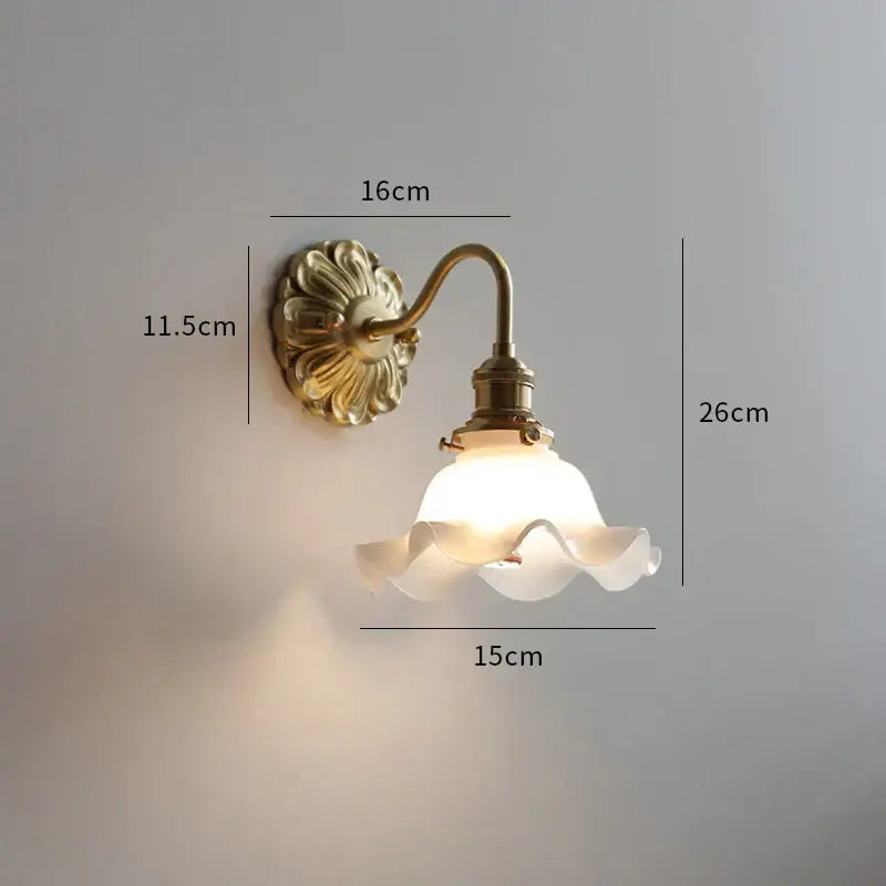 Antique brass wall lights featuring ribbed ceramic ball led design with frosted glass shade and ruffled edges for bedroom decorbites