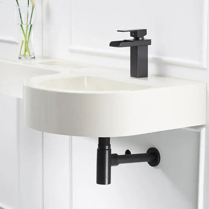 Modern black matte faucet with sleek rectangular spout on white sink paired with decorbites brass round bottle trap