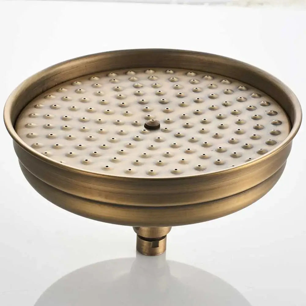 Antique brass round shower faucet set with handheld sprayer featuring a textured perforated circular showerhead