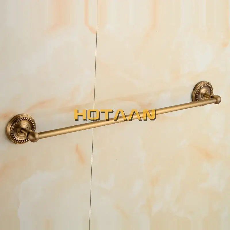 Antique brass single towel bar with ornate circular wall-mounted ends for classic bathroom decor