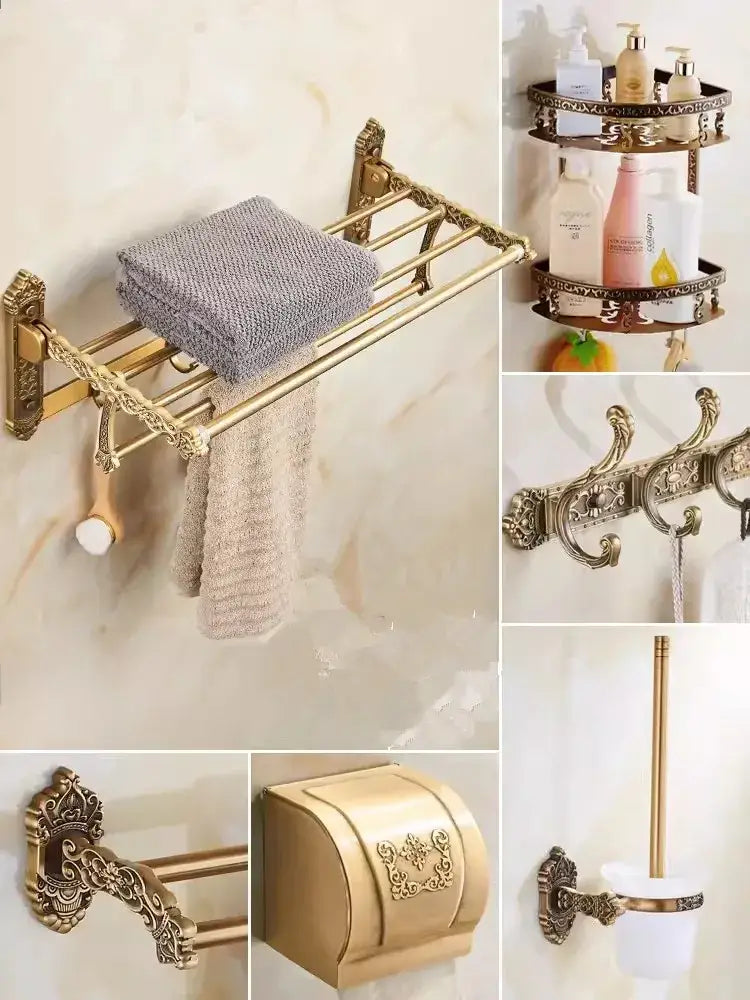 Gold-toned ornate decorbites bronze carved bathroom towel rack with decorative scrollwork holding folded gray towels