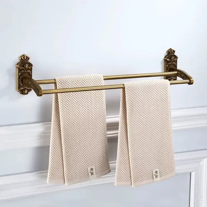 Beige textured towel with subtle dot pattern hanging on ornate decorbites bronze carved double-bar rack bath accessories set
