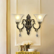 Antique bronze and gold crystal wall mounted light fixture with two frosted glass shades and crystal droplets for bedroom