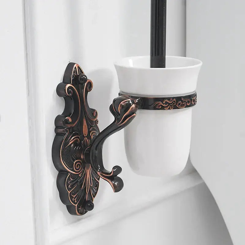 Antique bronze ornate wall-mounted toilet brush holder with a white ceramic cup for bathroom brush holder set