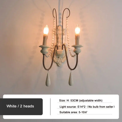 White two-head wall lamp with ornate curved arms and dangling teardrop pendants for decorbites country french wall decor