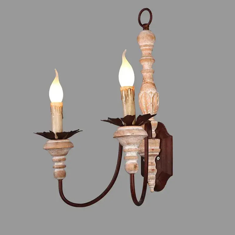 Antique double head French wall lamp with distressed white and brown wood finish and ornate dark metal bedroom sconce