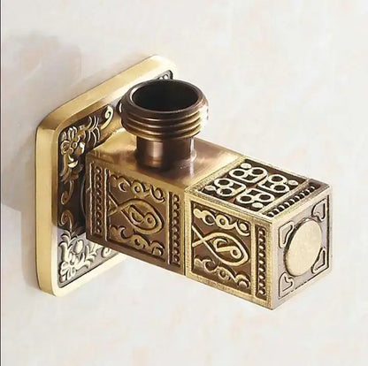 Antique floral brass bathroom angle stop valve with intricate fish and floral embossed designs on a rectangular body
