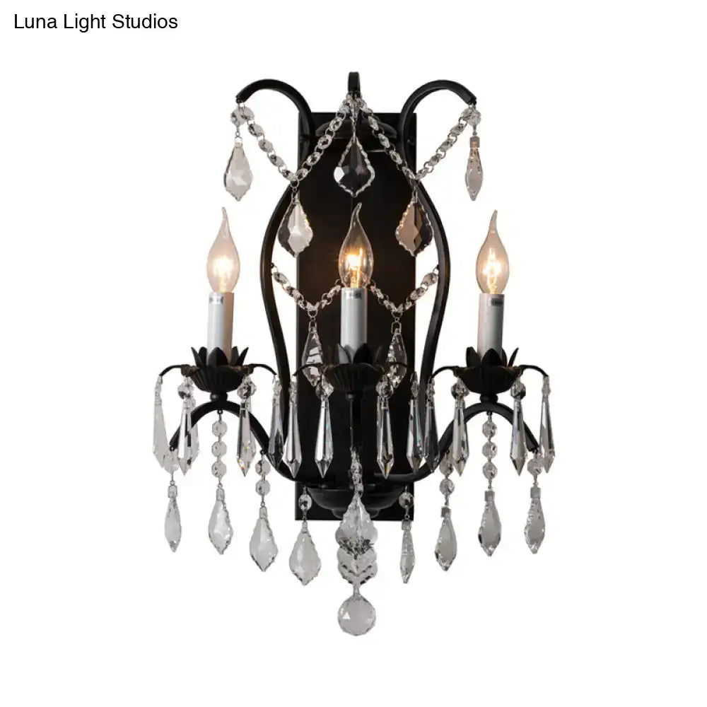 Black wrought iron candelabra wall light with three candle bulbs and cascading crystal droplets for dining room use