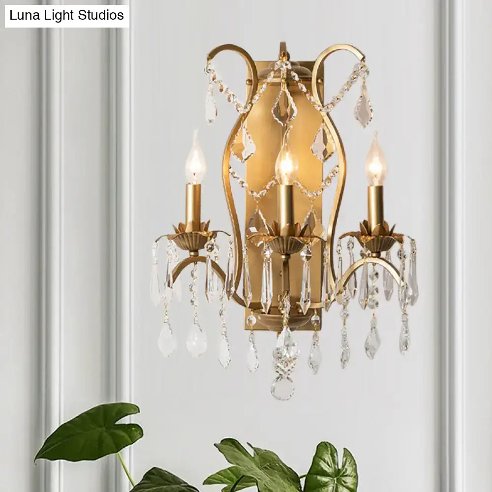 Antique gold candelabra wall light with three candle-style bulbs and crystal droplets for dining room decor