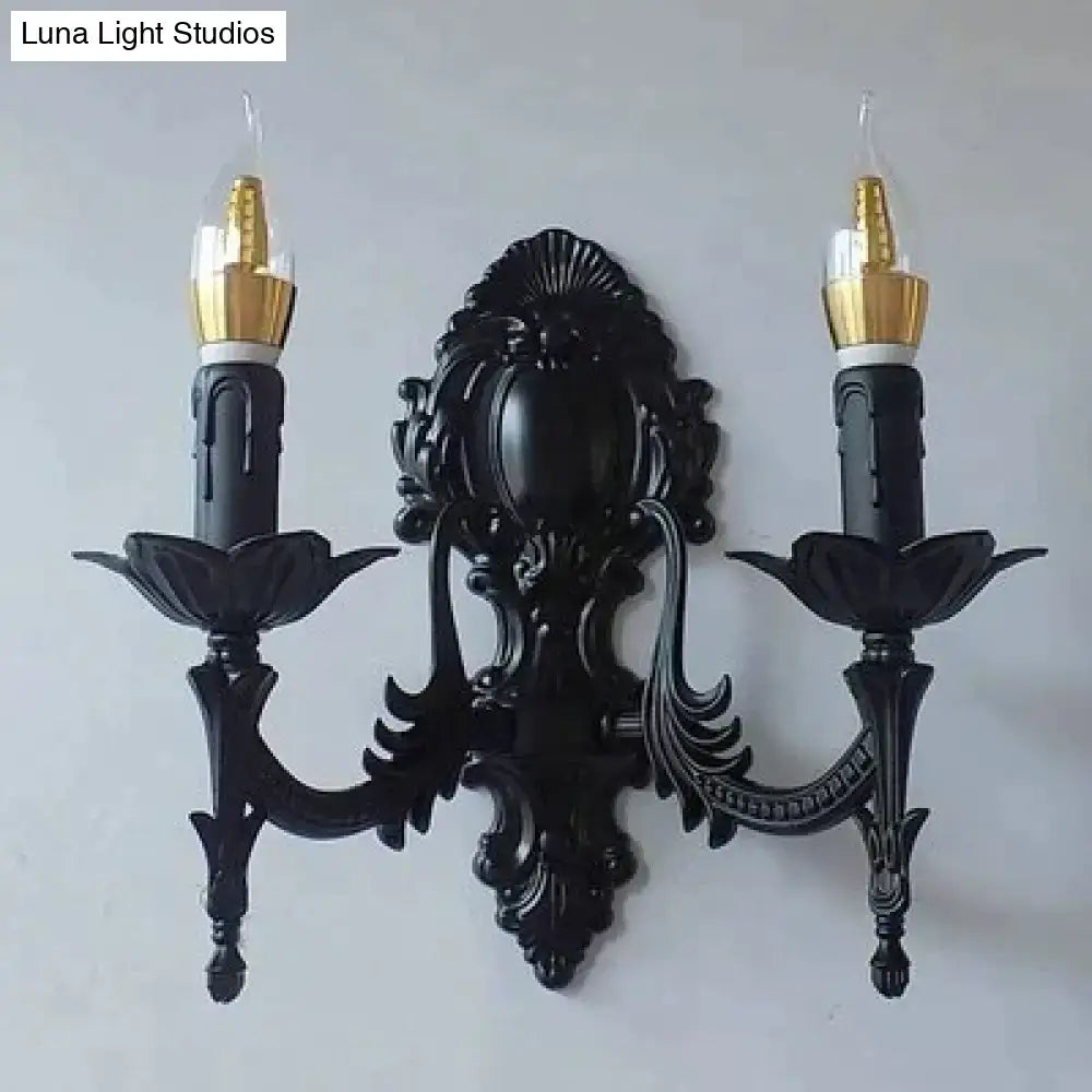 Black ornate wrought iron retro european wall sconce with two candle arms and gold finished bulb holders for bedroom lighting