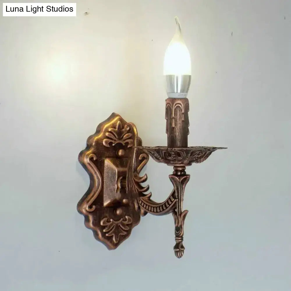 Antique bronze-finished creative retro european wall sconce with ornate candle-style design and single illuminated bulb