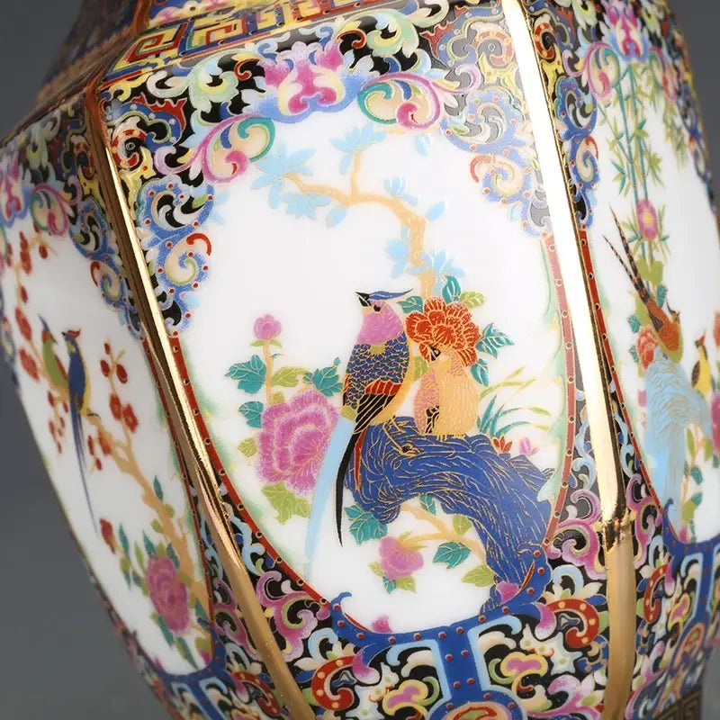 A vibrant hand-painted porcelain vase in blue pink gold and green with floral and bird motifs from an antique porcelain vase collection