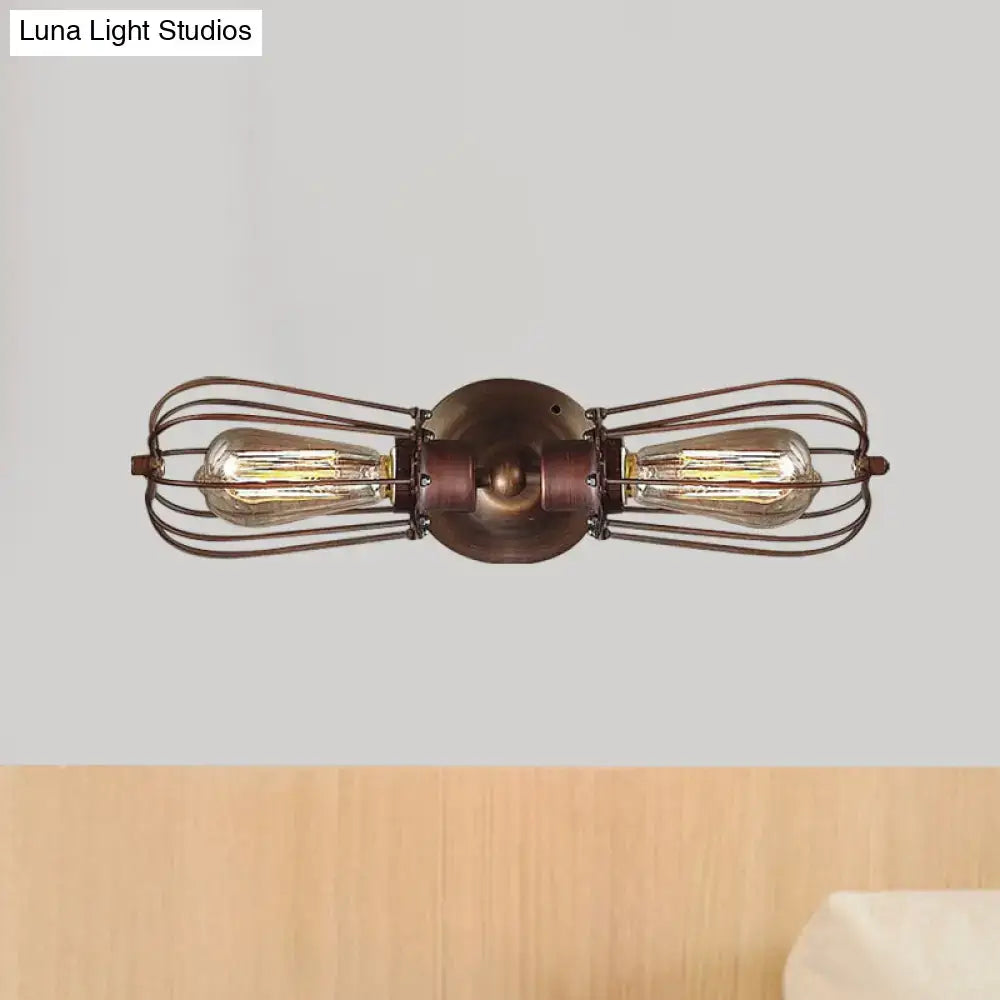 Antique style black bronze sconce light with two exposed edison bulbs in a dark bronze wire cage for dining rooms