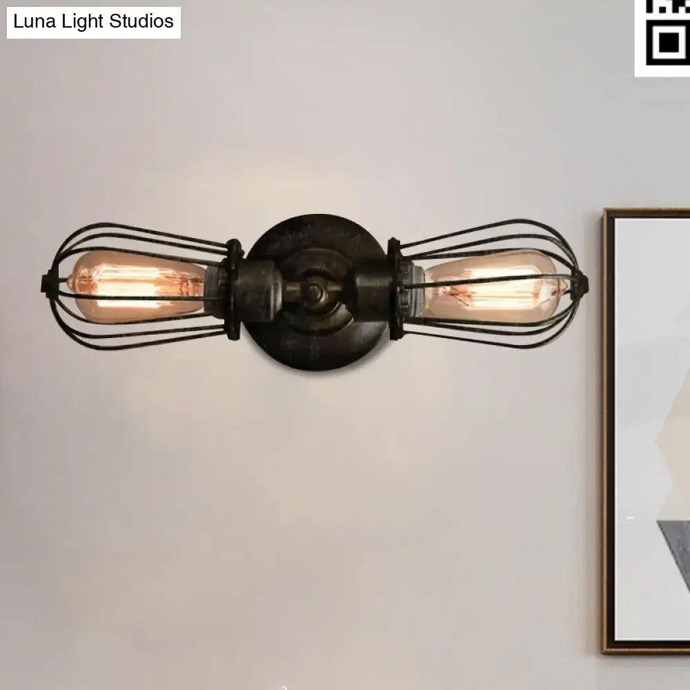 Antique style black bronze sconce light with two exposed edison bulbs in black wire cages and dark metal base