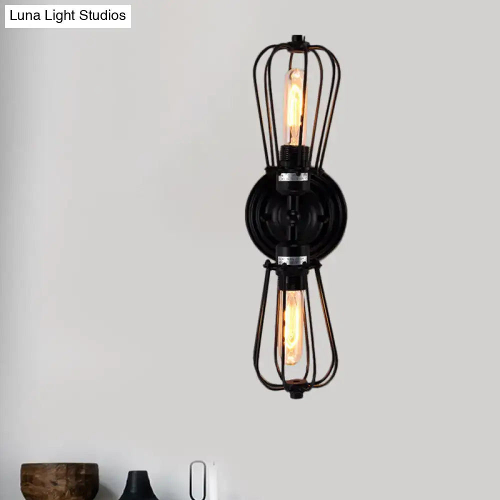 Antique style black bronze sconce light with industrial wire cage and two exposed filament bulbs for dining room wall