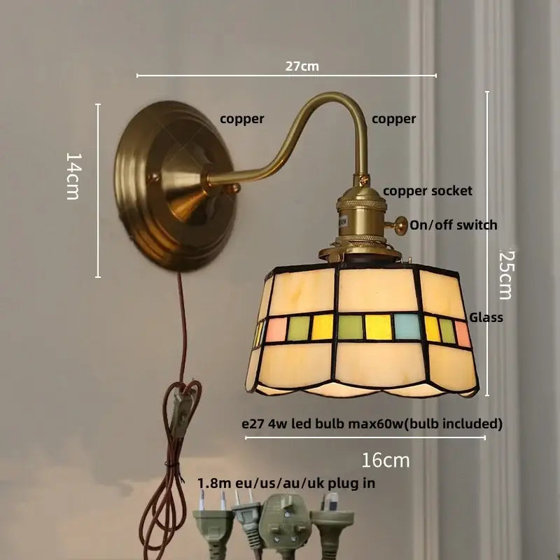 Antique brass-finished copper wall light fixture with teal glass and stained glass lampshade in warm tones for bedroom use
