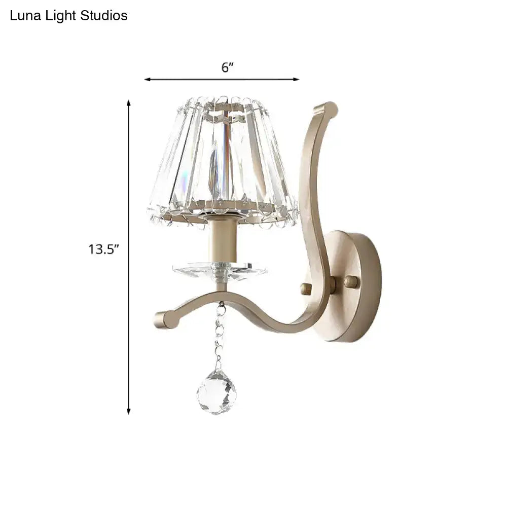 Antiqued gold wall mount light fixture with faceted crystal shade and teardrop crystal pendant for bedroom use