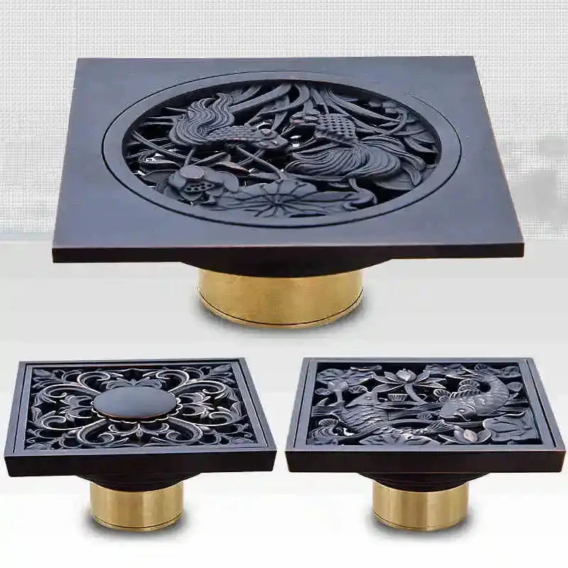 Black brass shower drain cover with intricate bird and flower carvings on a gold-toned metallic base decorbites black brass