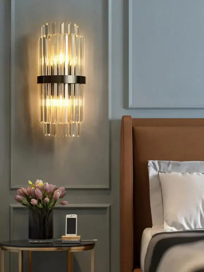 Art deco black gold stainless wall sconce with vertical crystal rods and sleek black metal band illuminating bedroom decorbites art deco