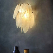 Art deco brass leaf sconce lamp with clear glass and a delicate translucent design for dining room lighting