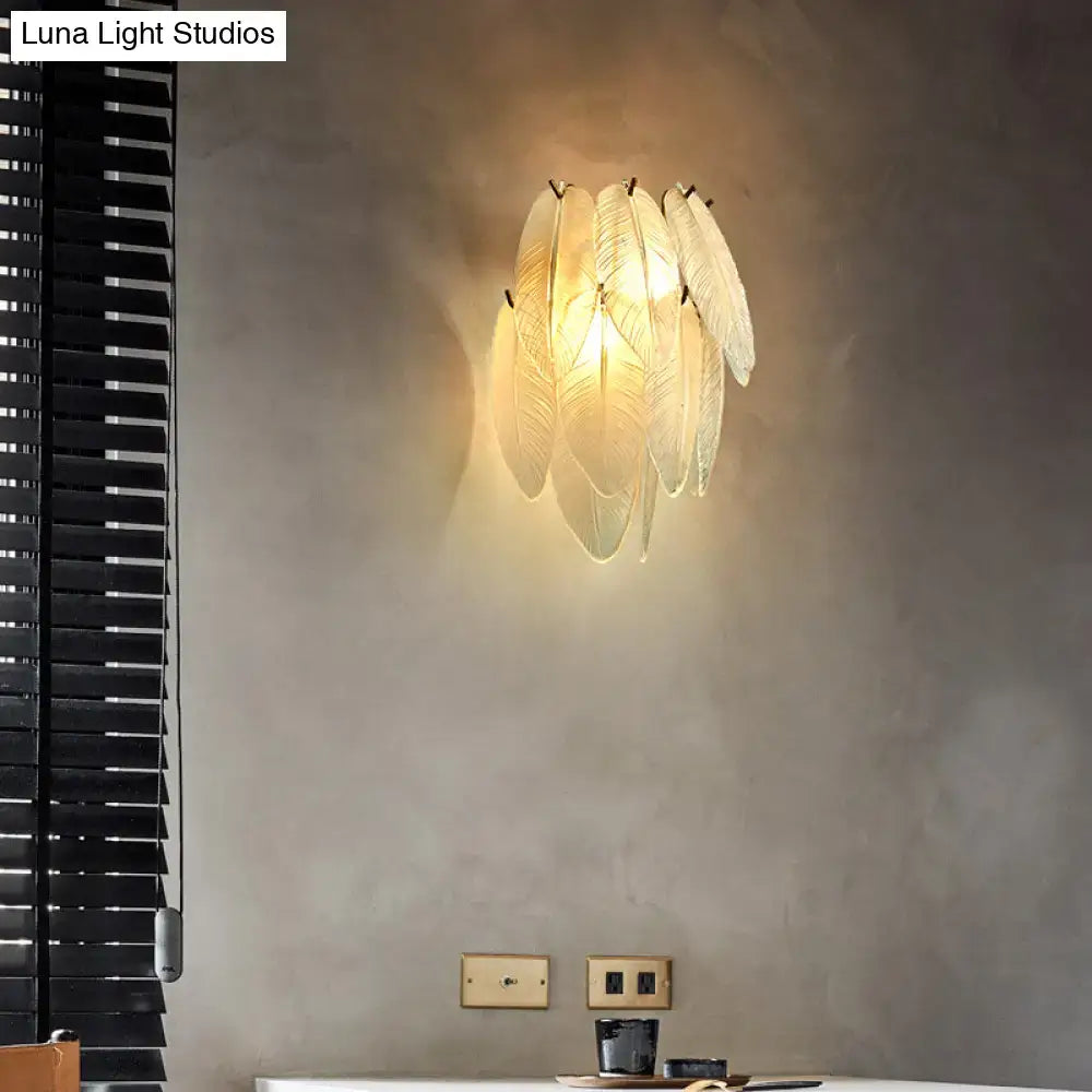 Art deco brass leaf sconce lamp with warm glowing clear glass feather-shaped shades for dining room lighting