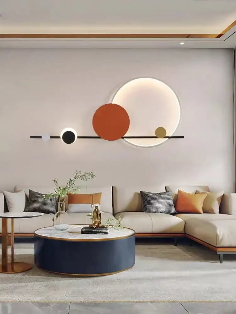 Modern geometric art deco led wall sconce with black orange and gold circular elements on light gray wall