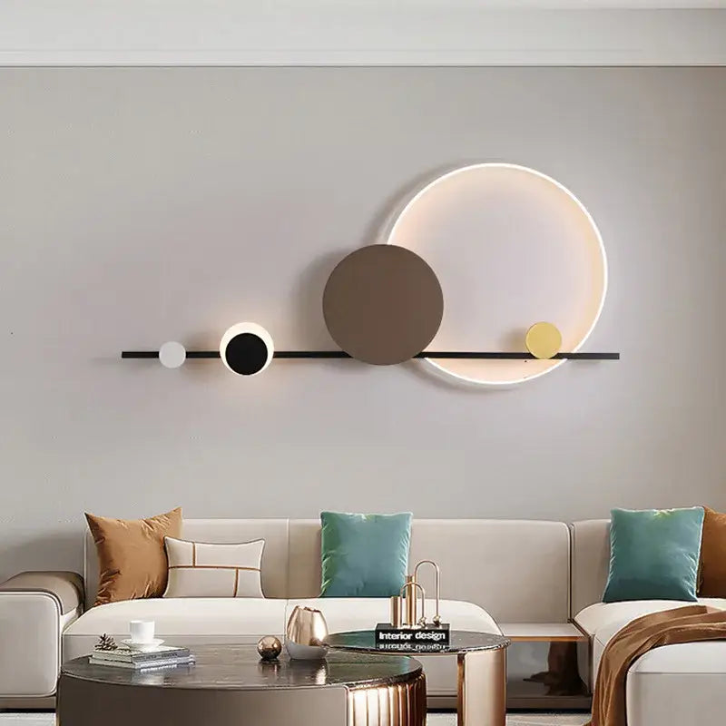 Modern art deco led wall sconce with a sleek black bar and glowing white brown and yellow illuminated circles