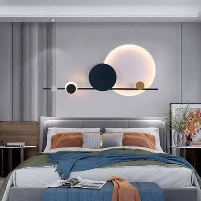 Modern art deco led wall sconce with black bar and three illuminated white navy blue and gold discs for bedroom lighting