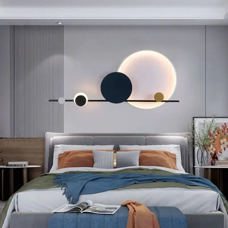 Modern art deco led wall sconce with black bar and three illuminated white navy blue and gold discs for bedroom lighting