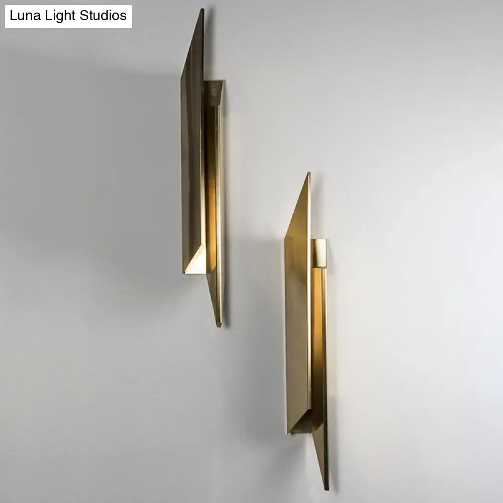 Modern gold-toned art deco wall lamp with geometric design and minimalist metallic finish for bedroom lighting