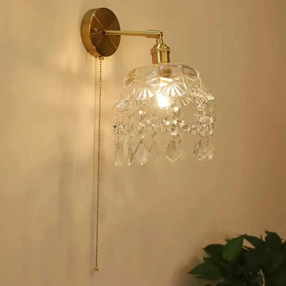 Brass-finished wall lamp with clear faceted crystal shade and teardrop crystals for decorbites art deco led lighting