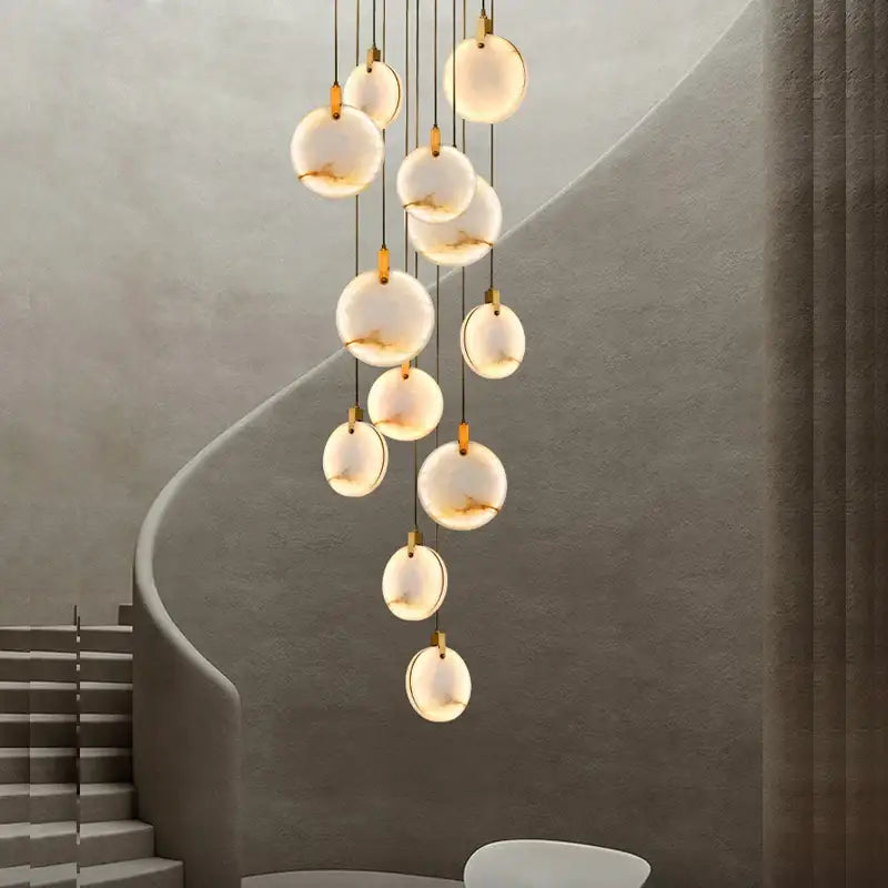 A modern art deco marble golden lustre pendant light with translucent white glass orbs for dining room lighting